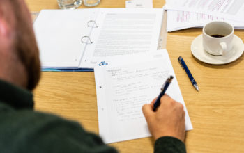 Man writing on CEDR-headed paper